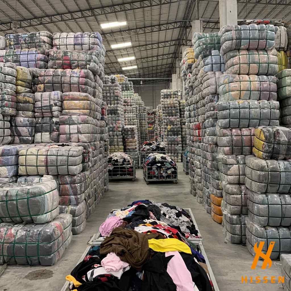 Large warehouse in Guangzhou filled with bulk secondhand clothing bales stacked high organized for export