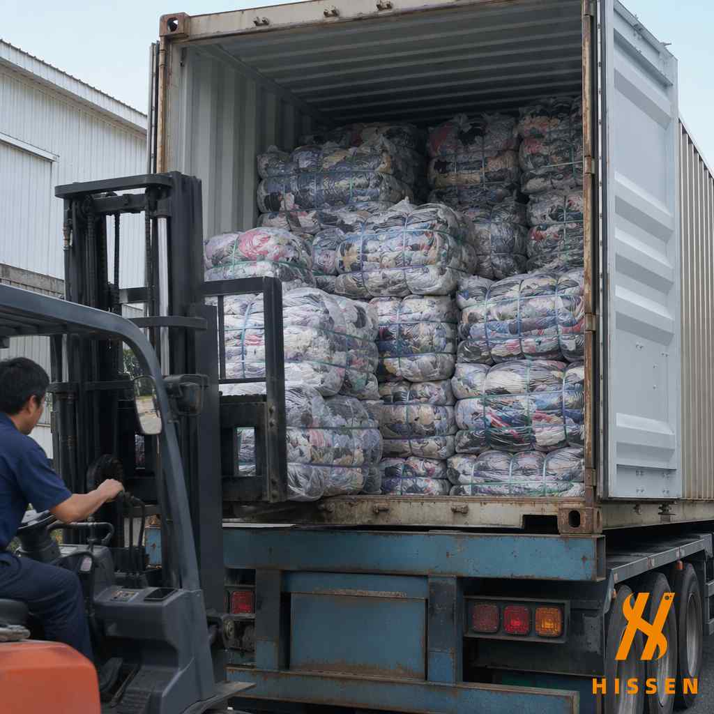 Premium Japan-sourced used clothing bales being loaded into a shipping container for export