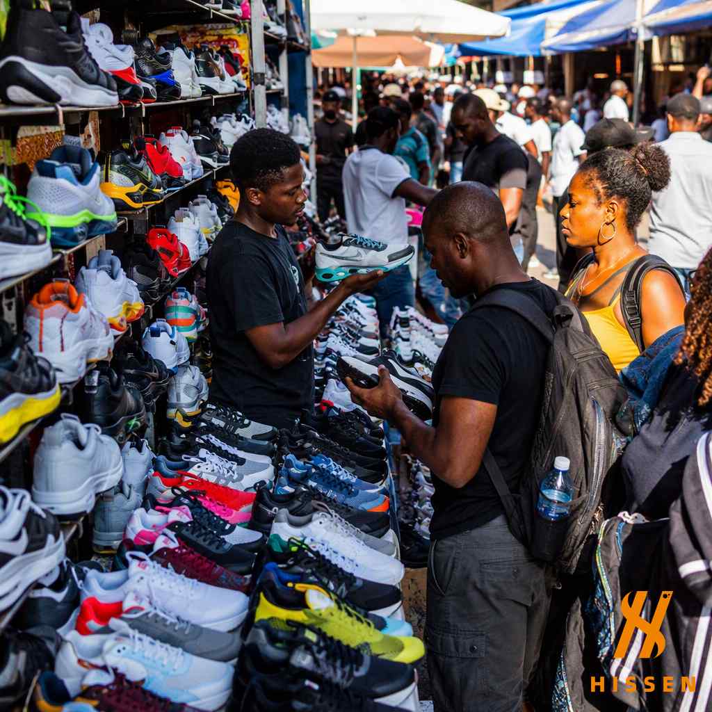 Street market vendor selling sports sneakers to customers